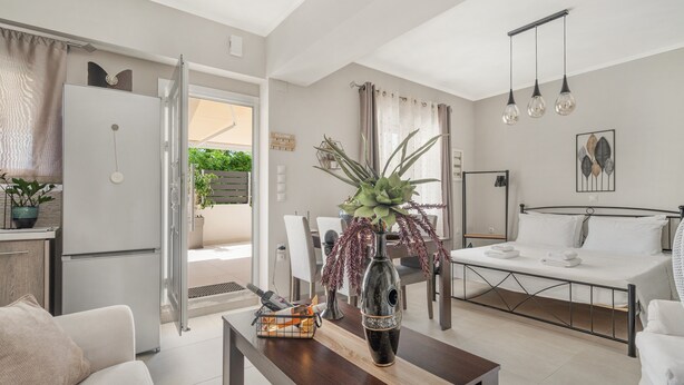 Una sala de estar moderna con comedor, cocina y un dormitorio con cama y mesita de noche.