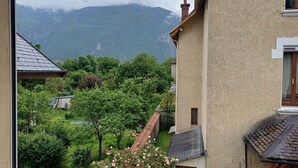 A residential building with a view of mountains and a garden with roses. - Apartment 'Le Chaussy' with Mountain View, Balcony and Wi-Fi (Saint-Etienne-de-Cuines)