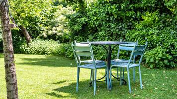 A round table with four chairs in a garden setting.
