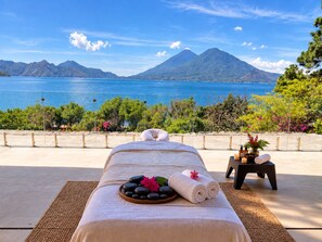 Ein Massagetisch mit Blick auf einen Berg und ein Gewässer.