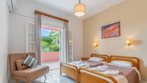 A bedroom with two beds, a chair, a window with curtains, a painting, and a ceiling light.