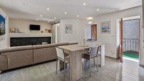 Una sala de estar moderna con sofá, mesa de comedor y televisor.