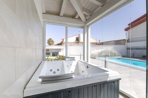 A modern outdoor hot tub area with a clear view of the pool and surrounding buildings. - Villa 'Maria Con Piscina Riscaldata' with Sea View, Wi-Fi and Air Conditioning (Santa Maria del Focallo)