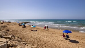 A beach with people, umbrellas, and a rocky shoreline. - Villa 'Maria Con Piscina Riscaldata' with Sea View, Wi-Fi and Air Conditioning (Santa Maria del Focallo)
