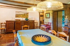 Un comedor con una mesa, sillas, un armario de madera y una lámpara colgante.