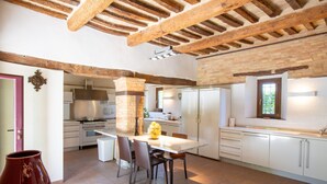 A kitchen with a central island, white cabinetry, and exposed wooden beams. - Villa 'Gelso' with Private Pool, Wi-Fi and Air Conditioning (Belvedere Ostrense)