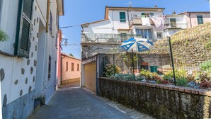 A narrow alleyway with a stone wall on one side and buildings on the other. - Amazing apartment in Carro with house a panoramic view (Carro)