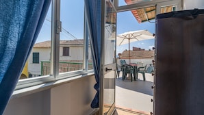 A room with a sliding glass door leading to an outdoor patio area with a table and chairs. - Amazing apartment in Carro with house a panoramic view (Carro)