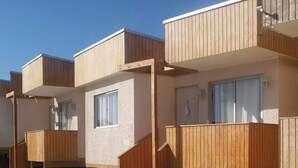 A row of modern apartment buildings with wooden balconies and large windows. - Cabañas Aquila D'Arroscia (Caldera)