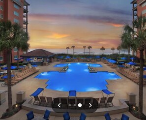 Relax by the resort's multiple pools, surrounded by shaded lounge areas and urban views.