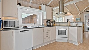 A modern kitchen with white cabinetry, a Bosch oven, a microwave, and a coffee maker. - Beautiful home in ålbæk with sauna (Ålbæk)