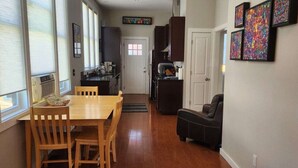 Un espacio habitable compacto con comedor, kitchenette y zona de estar.