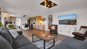 Ein modernes Wohnzimmer mit einer Couch, einem Couchtisch und einem Bild an der Wand.