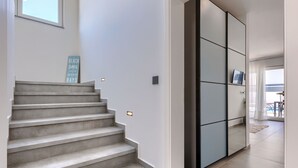 A modern staircase with a minimalist design, leading to a room with a large sliding glass door that opens to a balcony. - Blue Rose by Interhome (Pula/Vodnjan)