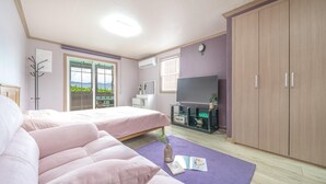 Un dormitorio con dos camas, televisión, armario y ventana con vistas.
