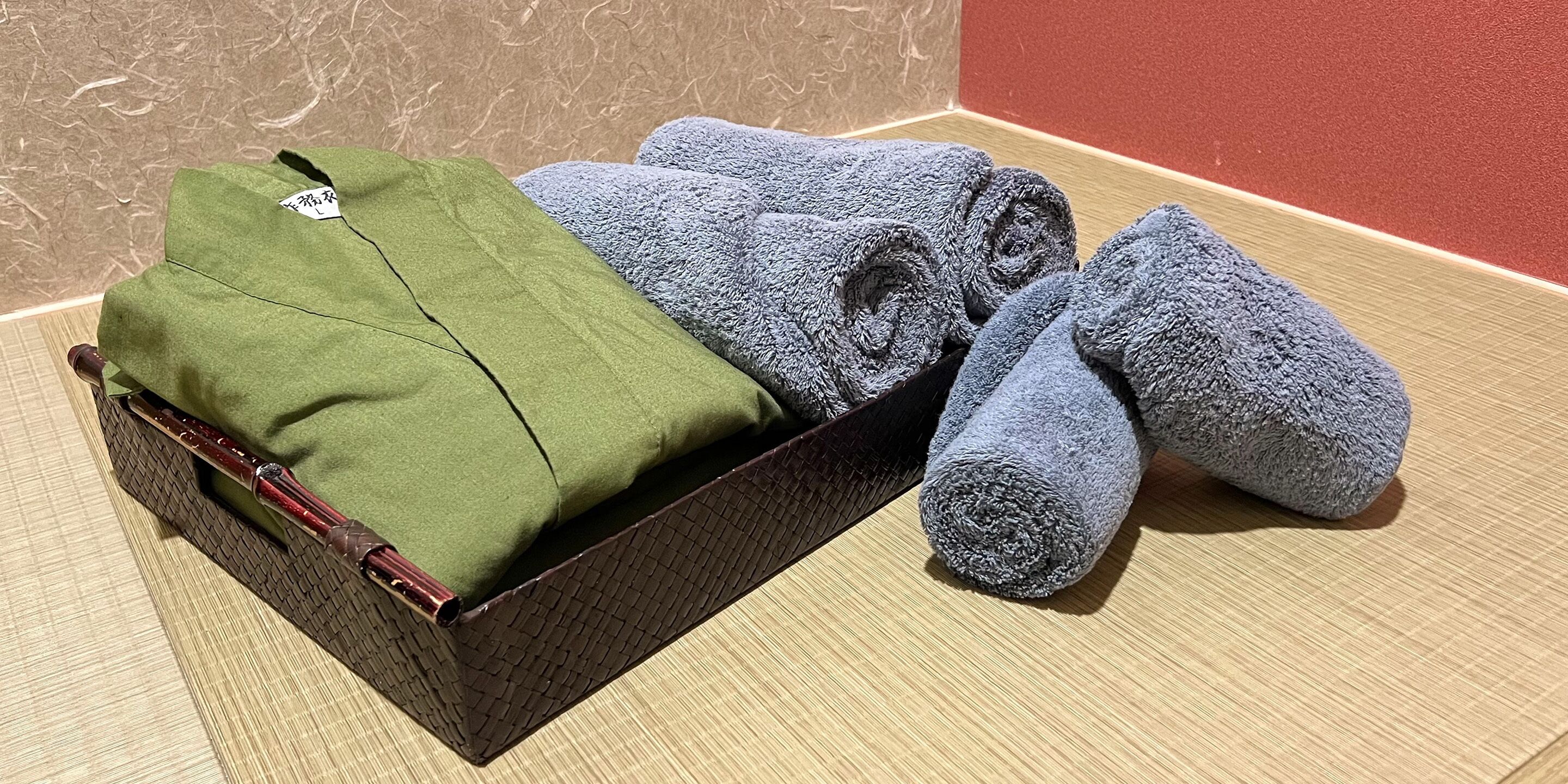 A box containing folded towels and a green garment.