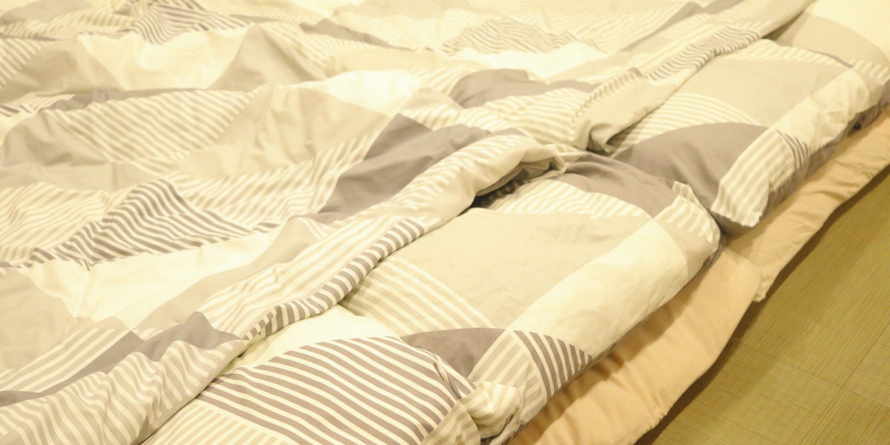 Una cama con ropa de cama y almohadas a rayas.
