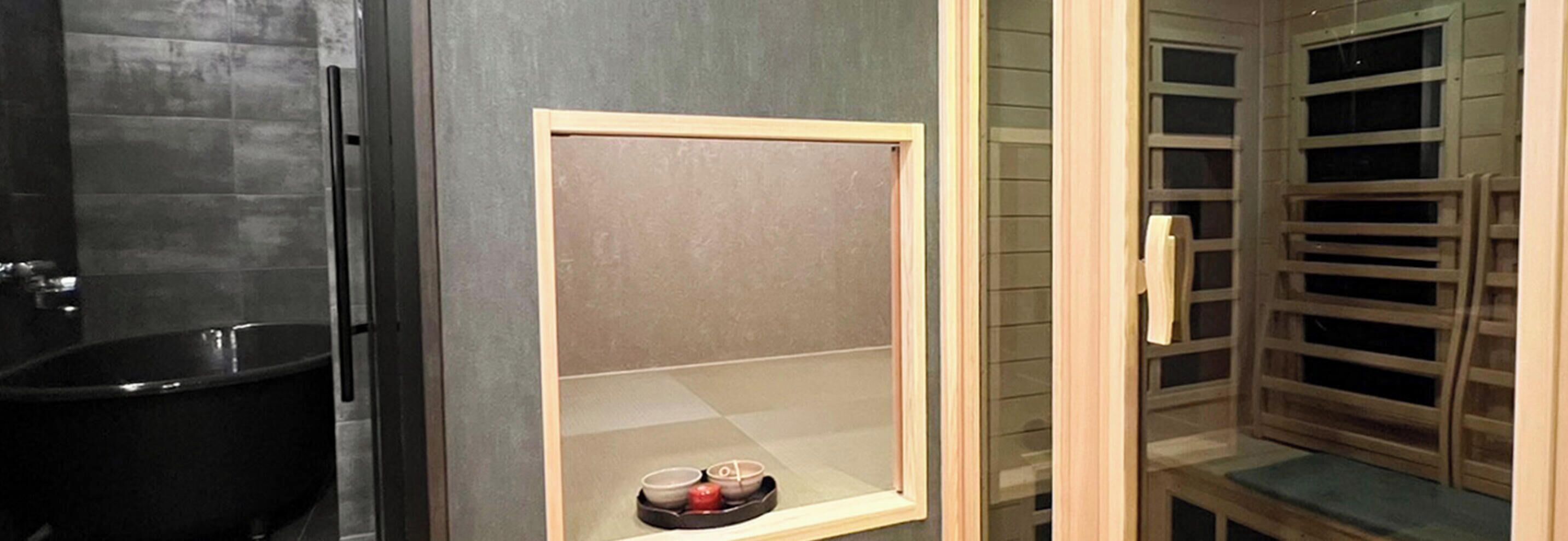 Un bagno con una vasca, uno specchio con cornice in legno e una cabina doccia in vetro.