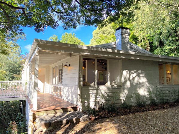 A single-story house with a porch, a chimney, and a deck. - Woolrich House at Woolrich Estate (Olinda)