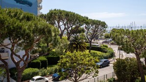 A coastal urban area with a prominent building featuring a mural of whales, lush greenery, and a clear view of the sea. - le ponant by Interhome (Saint Laurent du Var)