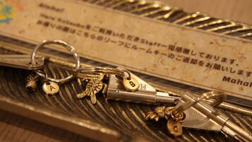 A set of keys with various keychains and a metal plate with Japanese text.