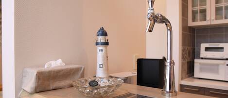 Una cocina con un grifo moderno, un faro decorativo y un microondas.