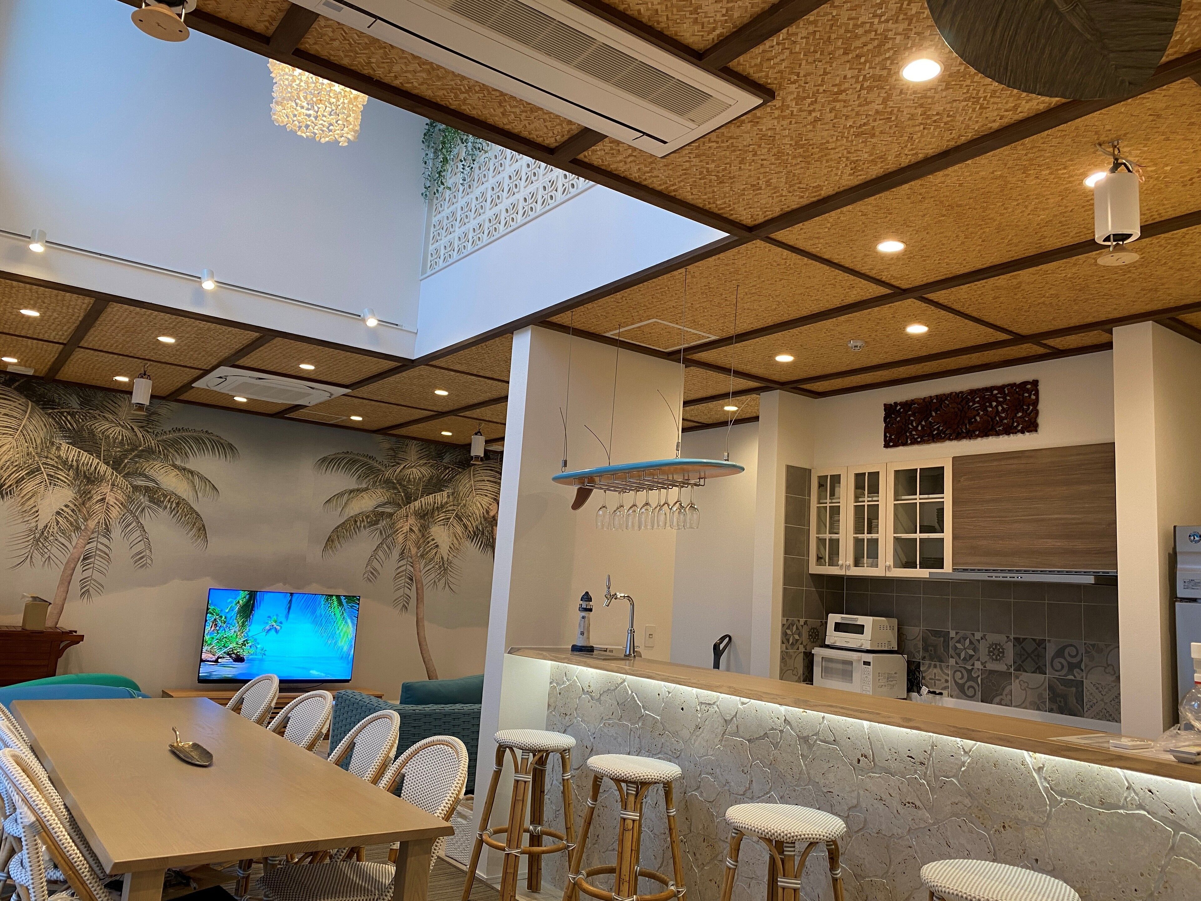 A modern kitchen with a stone countertop, white cabinets, and a microwave.