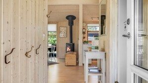 A wooden interior with a fireplace, a dining area, and a kitchen counter. - "Gligorij" - 450m from the sea by Interhome (Sæby)
