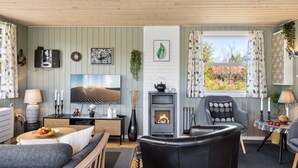 Una sala de estar acogedora con chimenea, asientos cómodos y televisor.