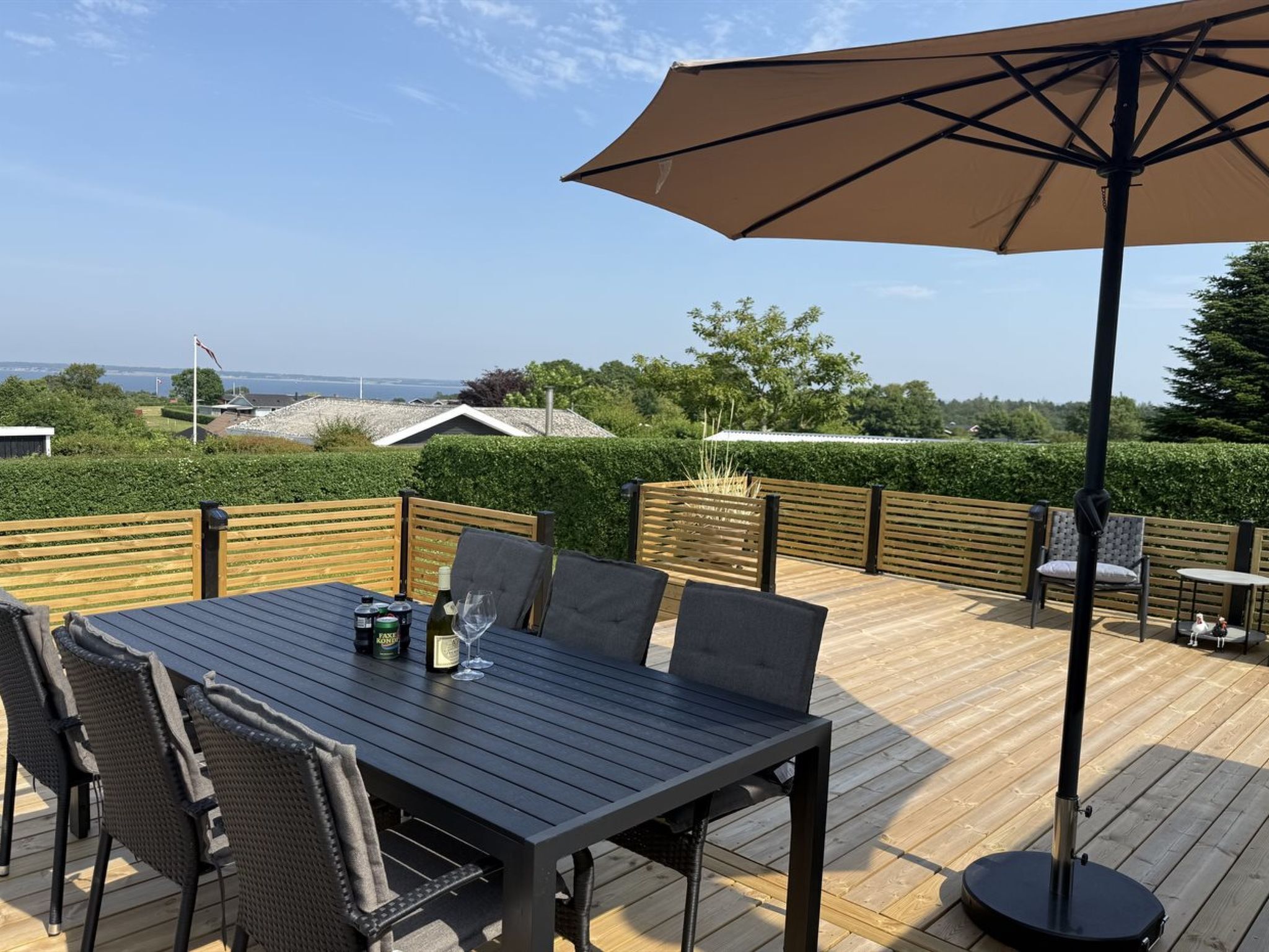 An outdoor patio with a table, chairs, and a large umbrella.