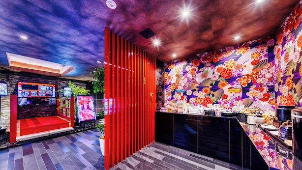 A restaurant interior with a red partition, a sushi bar, and a wall decorated with floral patterns. - Hotel Lotus Umeda - Adult Only　 (Osaka)