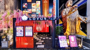 A hotel entrance with a large Buddha statue, signage for Hotel Lotus, and a red and black facade. - Hotel Lotus Umeda - Adult Only　 (Osaka)