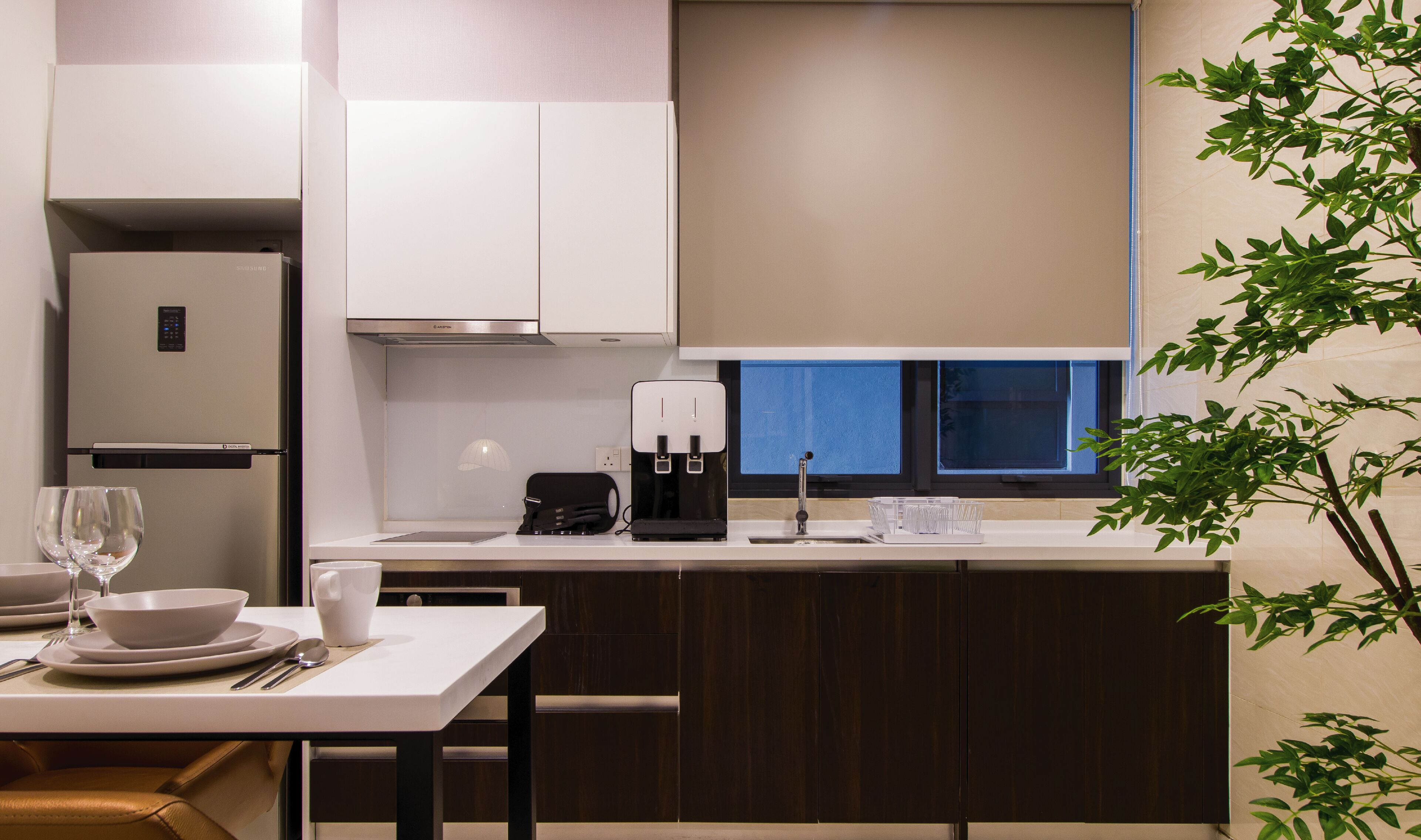 A modern kitchen with a built-in refrigerator, a coffee maker, and a window with a view.