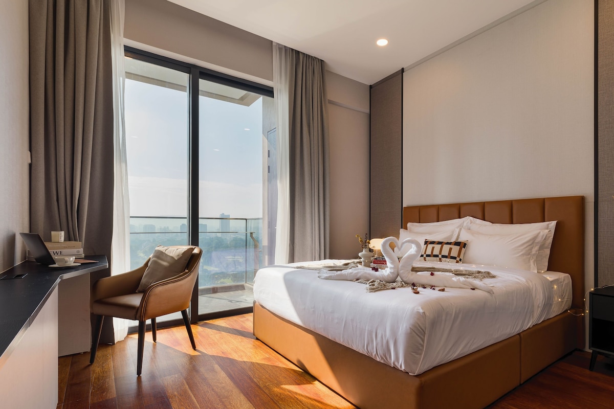 A modern hotel room with a large bed, a desk, and a view of the city.