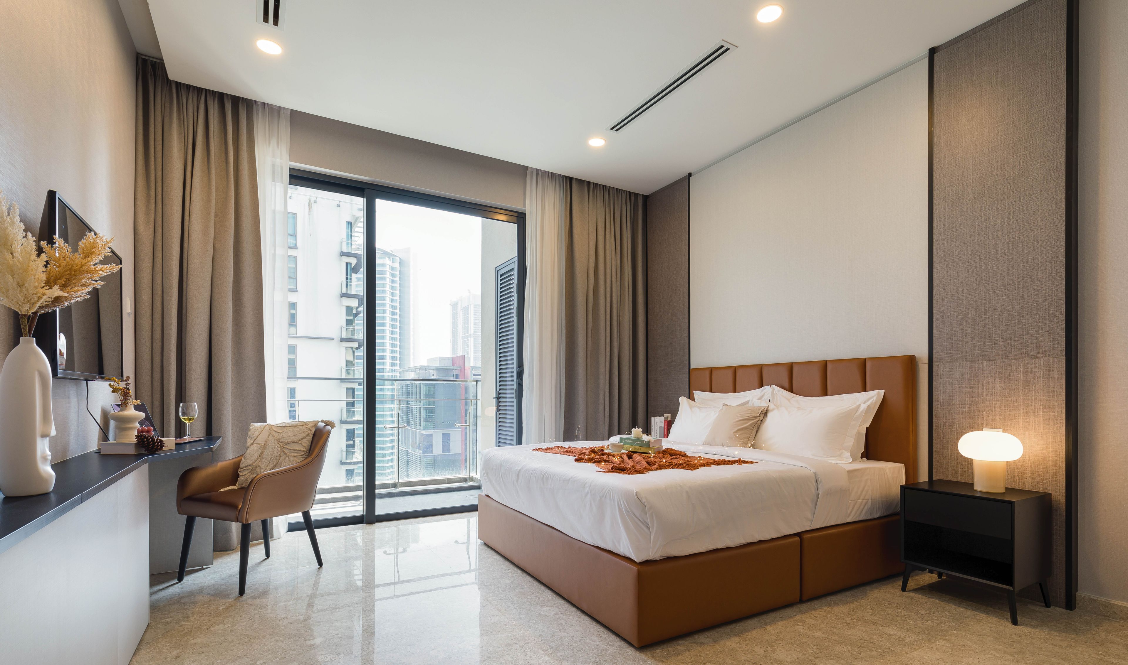 A modern hotel room with a large bed, a desk, and a chair.