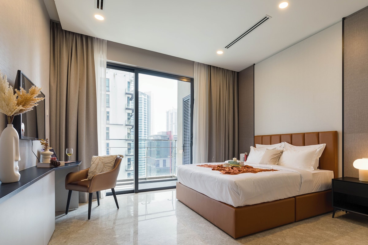 A modern hotel room with a large bed, a desk, and a chair.