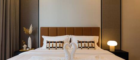 A hotel room with a neatly made bed, a bedside lamp, and a decorative vase with dried flowers.