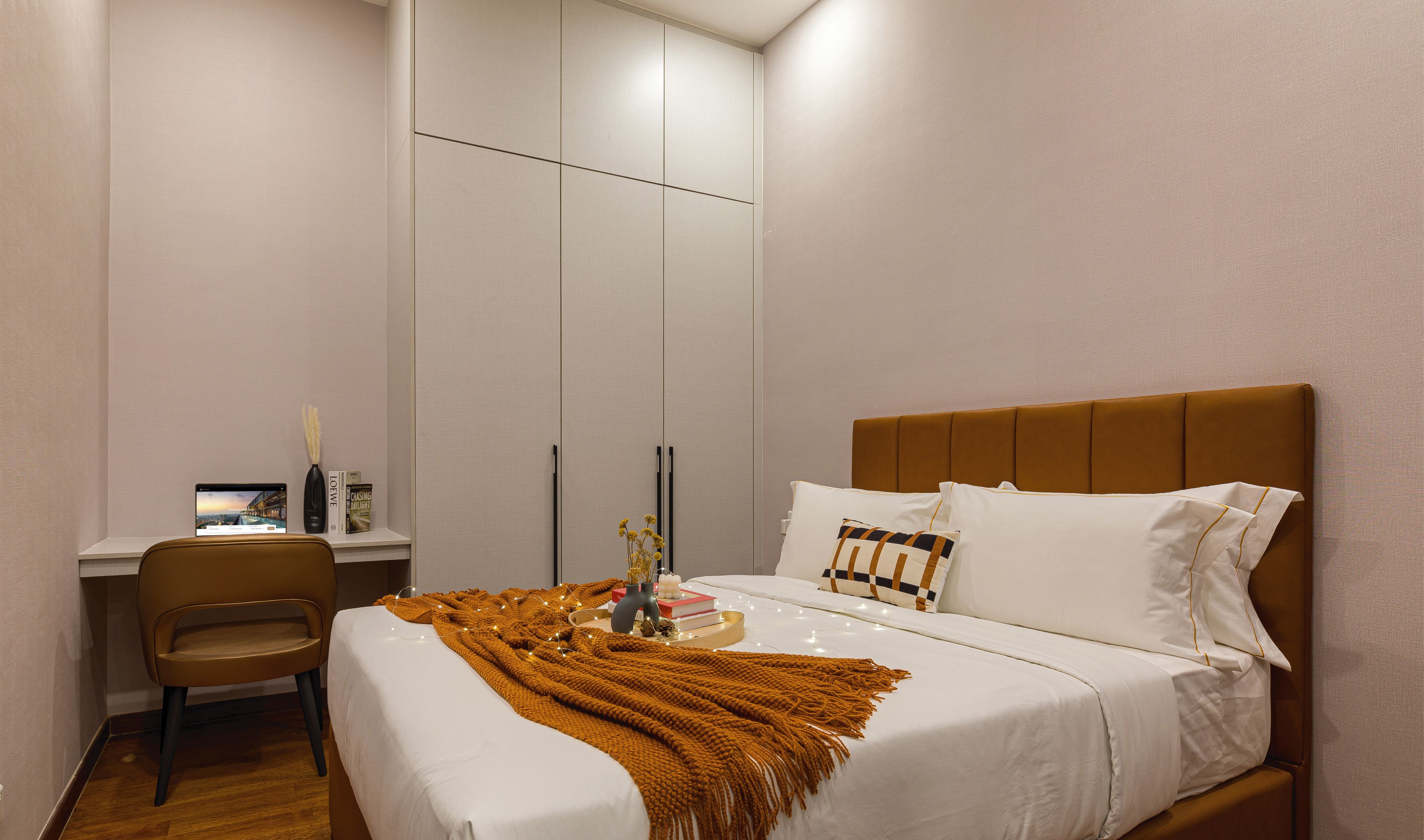 A bedroom with a bed, a desk, and a chair.