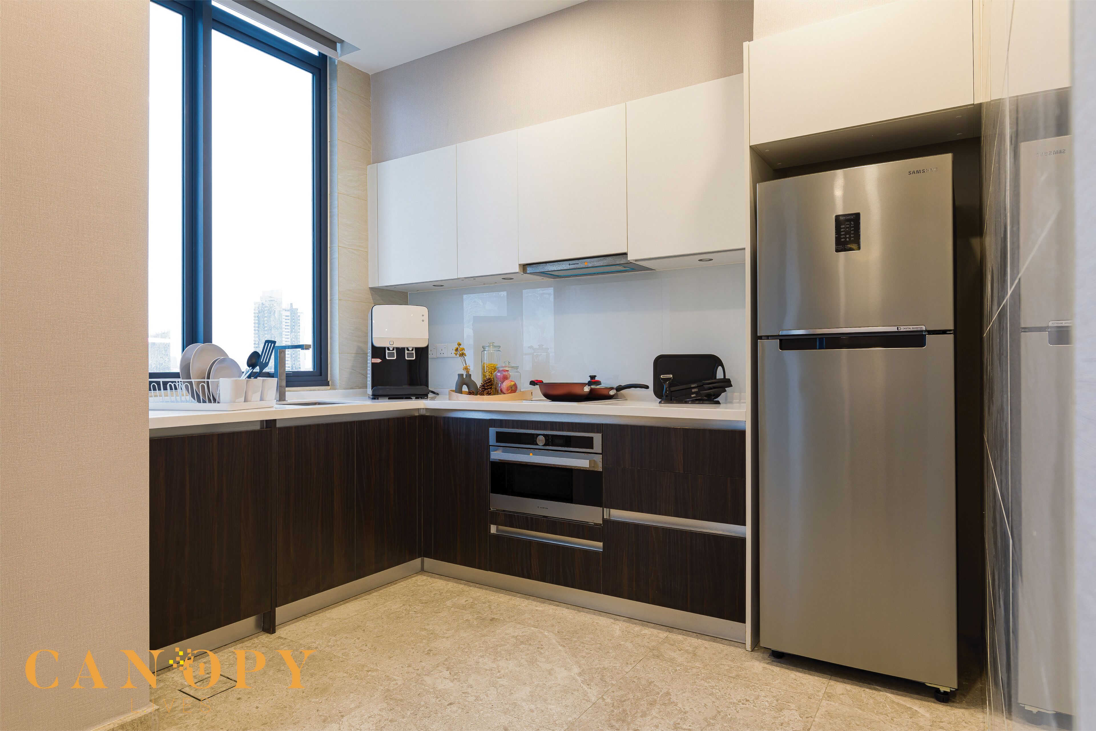 Een moderne keuken met donkere houten kastjes, roestvrijstalen apparatuur en een groot raam voor natuurlijk licht.