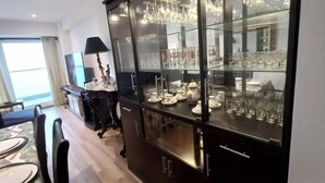 A modern kitchen with a glass-fronted cabinet displaying china and glassware. - Departamento con Vista al Mar (Lima)