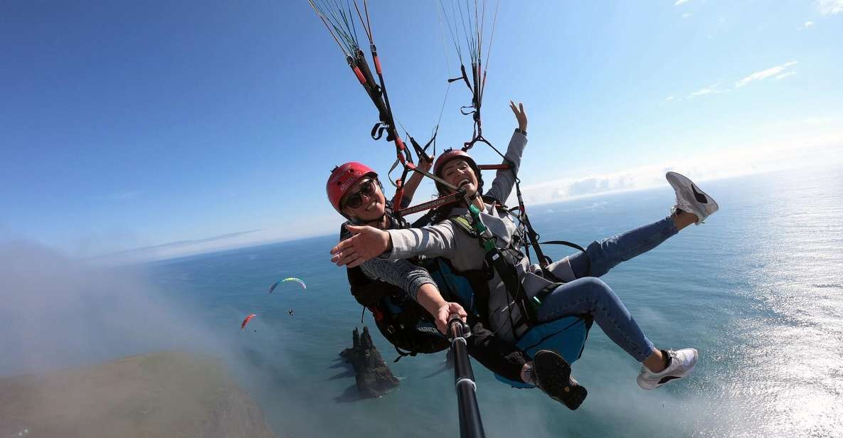 Una persona practica paratrike sobre una masa de agua, con cielo despejado al fondo.