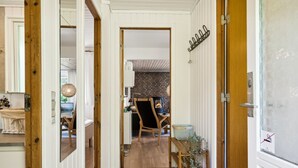 A hallway with wooden flooring, a dining area with a brick wall and a fireplace, and a door with a metal handle. - "Aleta" - 600m from the sea by Interhome (Grenaa)