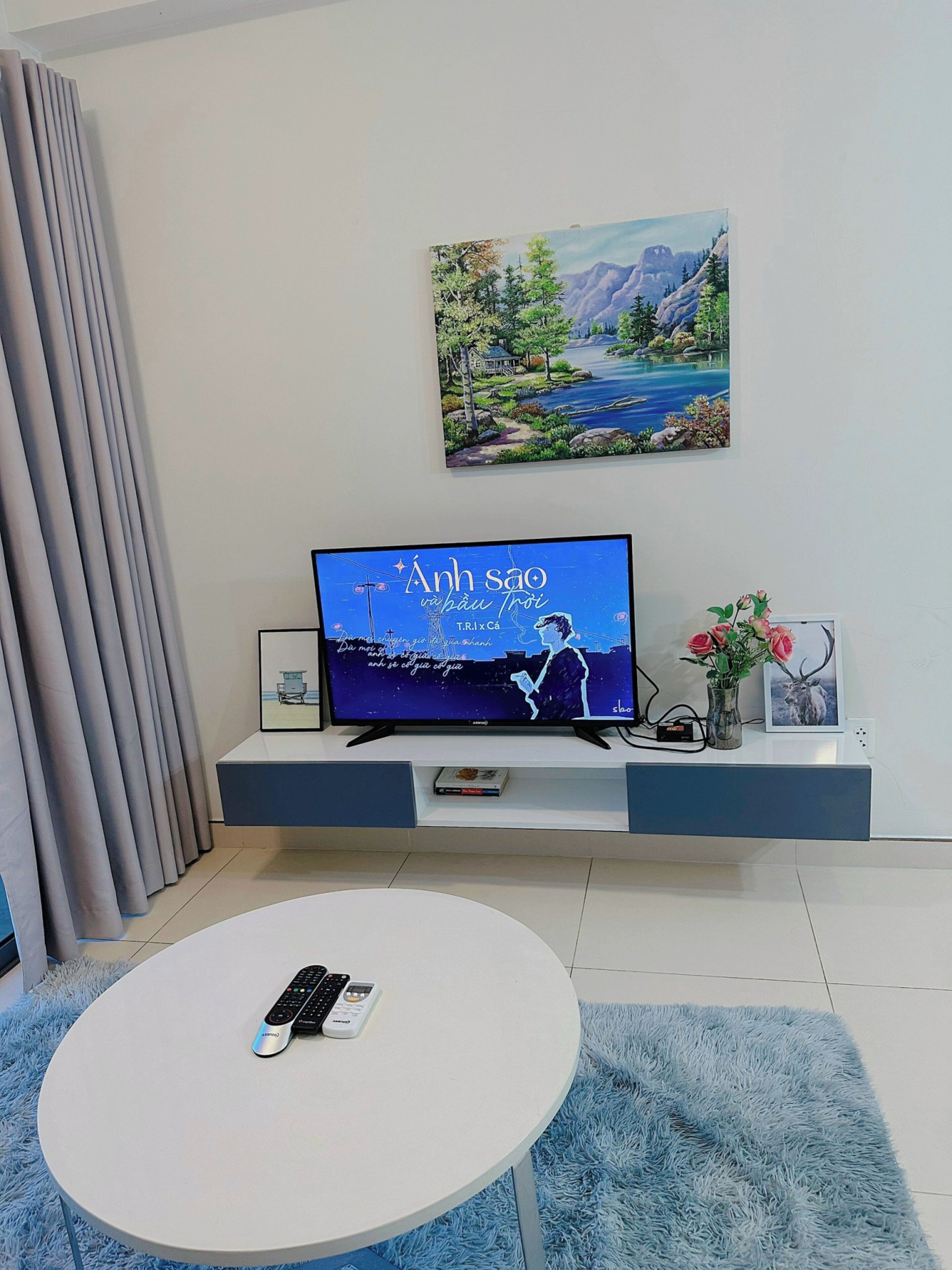 Una sala moderna con un televisor de pantalla plana, una mesa de centro y un cuadro colgado.