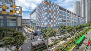 A modern building with a geometric facade, surrounded by greenery and a busy street. - The MASTERI ANGIA Prestige Suite By An Gia Hospitality (Ho Chi Minh City)