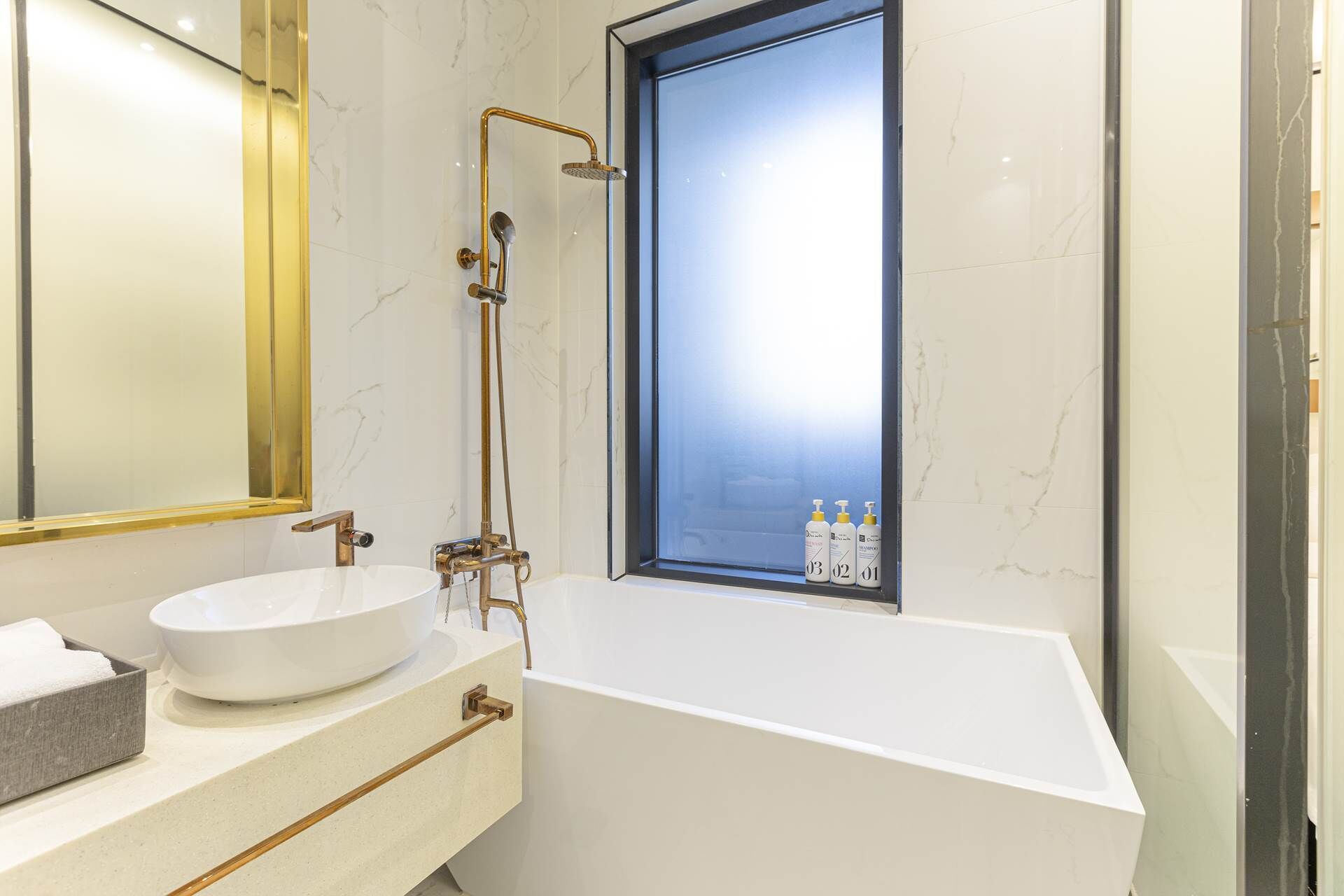 A modern bathroom with a freestanding bathtub, a large mirror, and a window with a view.