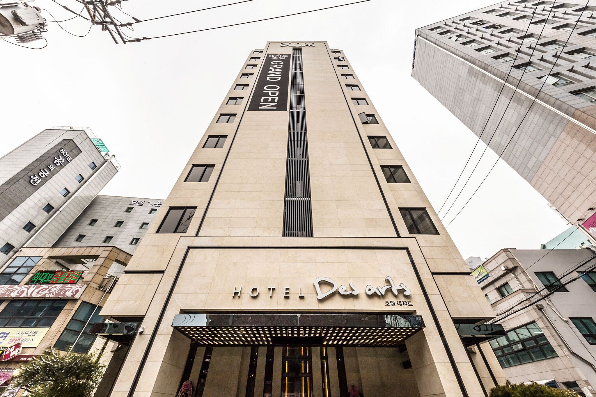 Un hôtel au design moderne, doté d’une entrée imposante et d’une enseigne indiquant qu’il s’agit d’un hôtel.