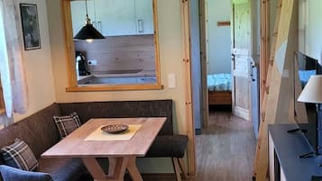 Ein gemütliches Interieur mit einem Holzespeisetisch, Stühlen, einer Couch und einer Küchenzeile.