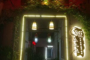 Entrada de un edificio con señalización iluminada y dos lámparas colgantes.