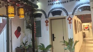 A traditional Chinese architectural entrance with arched doorways, hanging lanterns, and potted plants. - Tongli Ancient Town Forest Journey Design B&B (Suzhou)