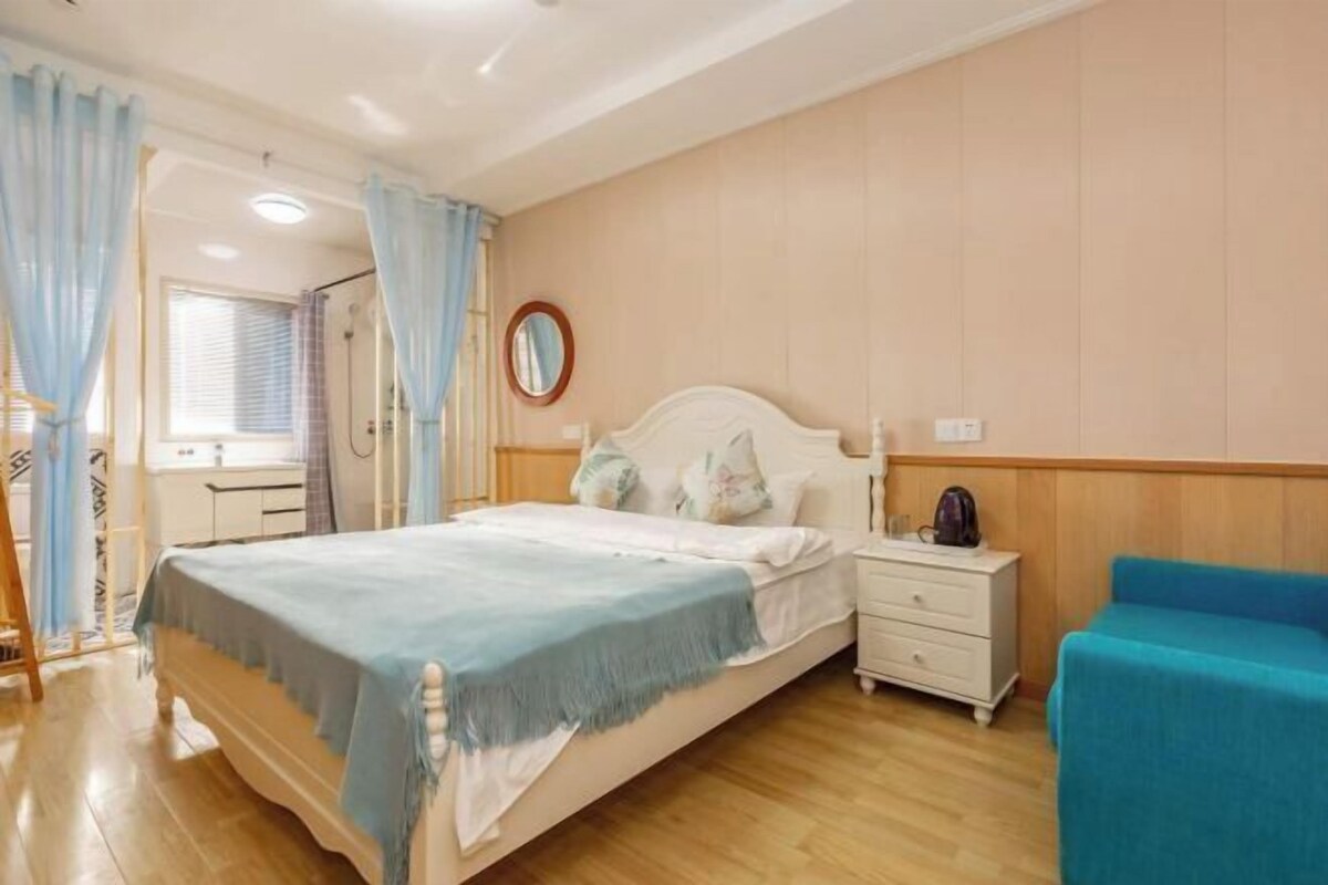 Une chambre à coucher avec un lit, une table de chevet et une chaise bleue.